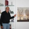 Heinz Haberland zeigt eines seiner neuen Bilder "Herbstliche Abendstimmung am Bodensee". In seinem Haus hat er mehrere Kunstwerke geschaffen. Im Badezimmer malte er eine toskanische Landschaft an die Wand.