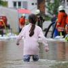 Ein Mädchen watet durch die überschwemmte Innenstadt von Veringenstadt (Baden-Württemberg - Kreis Sigmaringen). Die Stadt ist zum Teil überschwemmt, der Fluss Lauchert über die Ufer getreten. 