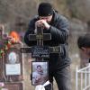 Ein Mann legt ein Kreuz auf das Grab eines ukrainischen Soldaten, der im Kampf um die Stadt Bachmut im Osten der Ukraine getötet wurde. 

