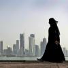 Eine Frau vor der Skyline der Stadt Doha in Katar.