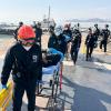 Gerettete Besatzungsmitglieder werden von Rettungskräften auf Bahren getragen, als sie in einem Hafen in Mokpo in Südkorae ankommen.