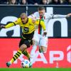 Dortmunds Donyell Malen (l) versucht den Ball vor Augsburgs Mads Pedersen (r) zu behaupten.