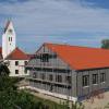 Das neue Bürgerhaus Mohrenhausen entsteht mitten im Dorfkern, dahinter ist die Kirche St. Leonhard und Sebastian.