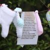 An einer Friedhofsmauer in Tuam hängen selbst gestrickte und gehäkelte Babysöckchen.  Socken und Namenslisten erinnern an all die Kinder, die in dem Ort starben.  