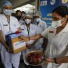 Eine Krankenschwester drückt in einem Regierungskrankenhaus der Millionenstadt Ahmedabad mit ihrem Finger rote Punkte auf eine Kiste mit Impfstoff. 