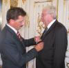 Vom damaligen Staatssekretär Georg Schmid bekommt Klaus Laske das Bundesverdienstkreuz für seine ehrenamtlichen Tätigkeiten.