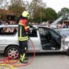 Unter den wachsamen Augen des Vorsitzenden Robert Kugelmann (li.) zerschneidet der Ettringer Feuerwehrkamerad mittels Rettungsspreizer das Fahrzeug. Das Publikum nimmt gebannt Anteil. 