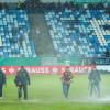 Im Ludwigspark-Stadion versuchen Helfer, Wasserlachen vom Spielfeld zu entfernen.