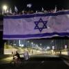 Demonstranten haben bei ihren Protesten eine riesige Nationalfahne an einer Autobahnüberführung in Tel Aviv aufgehängt.