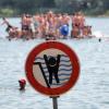 Ein Schild warnt an einem Badesee in Hessen vor einem stark abfallenden Ufer.