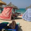 Menschen schützen sich bei extremer Hitze mit Strandtüchern vor der Sonne am Strand von Arenal.