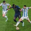 Argentiniens Julian Alvarez, Frankreichs Randal Kolo Muani und Argentiniens Lionel Messi kämpfen um den Ball.