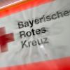 Das Logo des Bayerischen Roten Kreuzes ist an einem Rettungsfahrzeug zu sehen.