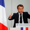 Emmanuel Macron, Präsident von Frankreich, neben der Trikolore und der EU-Flagge.