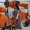 Ein Arbeiter kontrolliert am in Augsburg (Bayern) einen Roboter. KUKA stellt am 05.02.2013 die vorläufigen Geschäftszahlen vor.