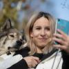 Nicole Lenhardt macht mit ihrem Wolfshund Milo in einem Weinberg ein Selfie.