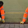 Fleißig bei der Arbeit sind Mezelo Debesan (links) und Jemil Nurodin im Sportzentrum in Illertissen. Als gemeinnützige Arbeiter in den Reihen des Bauhofes kümmerten sie sich am Montag um die Abflussrinnen am Kunstrasenplatz. Sie kommen beide aus Eritrea und wurden dort in den Kriegsdienst gezwungen.  
