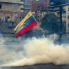 Demonstranten stehen mit Masken in einer Tränengaswolke in Caracas, wo es bei einer Massendemonstration zu Ausschreitungen kam. Die Opposition fordert Neuwahlen und macht Präsident Nicolás Maduro für die schwere politische und ökonomische Krise in dem Land mit den größten Ölreserven verantwortlich.