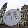 Ein Schild auf dem Rathausplatz in Augsburg weist auf die Maskenpflicht hin. Über die aktuell geltenden Regeln herrscht bei Bürgern oft Verwirrung.