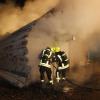 Die Feuerwehrmänner versuchen das brennende Holzlager zu löschen. Sie befürchteten jedoch, dass das Löschwasser nicht ausreichte. 