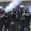 Sicherheitskräfte der Nationalgarde feuern in Caracas Tränengas in Richtung protestierender Demonstranten.