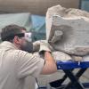 Mit einem Druckluftstichel bearbeitet Frederik Spindler im Dinomuseum Denkendorf einen Sandsteinblock, in dem sich Knochen eines Riesenlurchs verbergen.