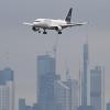 Ein Passagierflugzeug der Lufthansa ist vor der Frankfurter Skyline im Landeanflug auf den Frankfurter Flughafen.