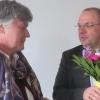 Pfarrer Tobias Praetorius überreicht der Vereinsvorsitzenden Elisabeth Eisenmann mit Blumen.  	