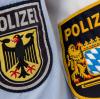 Die Hoheitsabzeichen der Bundespolizei und der bayerischen Bereitschaftspolizei hängen an der Grenzkontrollstelle "Schwarzbach" an der A8 bei Piding einträchtig nebeneinander.