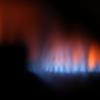 Eine Gasflamme brennt hinter dem Sichtfenster eines Gas-Durchlauferhitzers. Das Gas wird gerade teurer, der Staat will helfen.