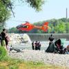 Landung im Flussbett: Ein Rettungshubschrauber landete auf einer Kiesbank unterhalb des Wehres. Etliche Badegäste wurden Zeugen des Unglücks. Foto: Sabine Streck