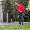 Peter Neururer übt in seinem Garten Golf.