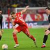 Joshua Kimmich (M) kämpft gegen Freiburgs Vincenzo Grifo (l) und Michael Gregoritsch um den Ball.