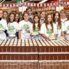 Sichtlich stolz präsentieren sich die Mitglieder der Projektgruppe „Die gute Schokolade – Schuledition“, flankiert von Beate Duling (links) und Projektkoordinatorin Stefanie Doll, an den Verkaufspaletten im Rewe-Markt an der Gartenstraße. 	
