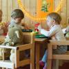 Kinder einer Kita sitzen an einem Tisch und essen: In Augsburg werden in einem Jahr viele Eltern ohne einen Krippenplatz für ihre Kinder dastehen. 