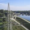 Monteure sind auf einen Strommast am Wasserkraftwerk Ellgau geklettert. Sie erneuern dort die 110-Kilovolt-Stromleitungen. 	