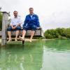 Klaus Holetschek (l), Staatsminister für Gesundheit und Pflege, und Markus Söder (beide CSU), Ministerpräsident von Bayern, sitzen auf einem Badesteg.