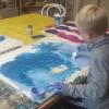 Alexander malt einen blauen Hintergrund für seine „verrückte Maschine“.