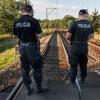 Polnische Polizisten patrouillieren an der Bahnstrecke.