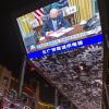 Auch in China weiß man: Der US-Präsident  macht Tempo. Eine riesige Videowand in Peking zeigt Joe Biden beim Unterzeichnen von Dekreten.      