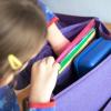 Beim Packen des Schulranzens sollte darauf geachtet werden, dass schwere Dinge wie Bücher dicht am Rücken getragen werden. 