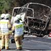 Eine Gruppe Feuerwehrmänner schaut auf den Bus, in dem am Montag vor einer Woche 18 Menschen verbrannten.