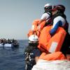 Seenotretter der "SOS Mediterranee" halten Rettungswesten für die in Seenot geratenen Migranten bereit.