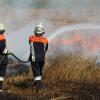 Feuerwehrleute löschen ein brennendes Weizenfeld zwischen Oettingen und Auhausen. 