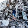 Ein Bewohner geht über die Trümmer eines eingestürzten Wohnhauses in Charkiw.