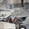 Rettungskräfte stehen in Damaskus an dem durch den Luftangriff zerstörten Gebäude.