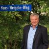 Hans Weigele war 48 Jahre lang in der Kommunalpolitik in Schöneberg und Pfaffenhausen engagiert, die meiste Zeit als Erster oder Zweiter Bürgermeister. Auch wenn es vielleicht auf den ersten Blick so aussieht: Eine Straße hat man ihm (noch?) nicht gewidmet. Das Schild, das auf seinem Privatgrund steht, bekam er vor Jahren zum Geburtstag geschenkt. 	