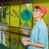 Künstlerin Lisa Frühbeis vor den von ihr künstlerisch neu gestalteten Fenstern im Hallenbad Göggingen.