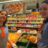 Carina Wiedemann (links) und Sonja Riedmüller füllen mit Handschuhen die Regale in der Obst- und Gemüseabteilung auf.