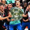 Bayerns Torhüter Manuel Neuer (M) und seine Teamkollegen jubeln nach dem Gewinn der 33. deutschen Meisterschaft mit der Meisterschale.